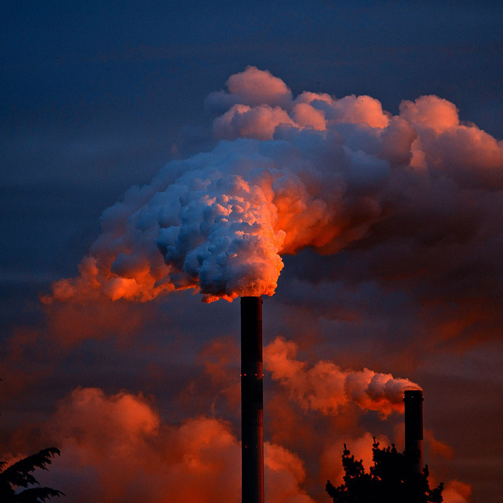 smoke coming out of an industrial chimney at sunset